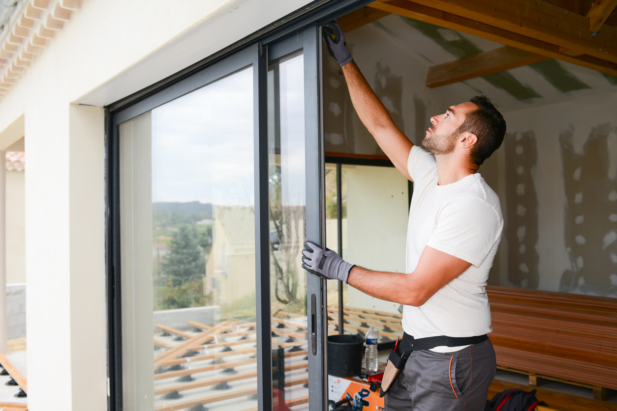 Ett hus som renoveras, en man installerar en dörr